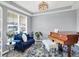 Bright living room with plush blue sofa, decorative pillows, wood floors and a modern chandelier, perfect for relaxation at 16516 Wilsons Farm Dr, Fishers, IN 46040