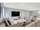 Relax in this spacious living room with soft, neutral furniture, large screen television, and a cozy area rug at 16516 Wilsons Farm Dr, Fishers, IN 46040