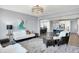 Cozy living room with stylish seating, a modern light fixture, and an open view to the dining and kitchen areas at 16516 Wilsons Farm Dr, Fishers, IN 46040