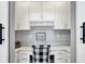 Cozy office nook with built-in white cabinets, desk, and a black and white patterned chair at 16516 Wilsons Farm Dr, Fishers, IN 46040