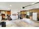 A spacious garage with room for storage, racks, and shelving along wood panel walls, with an adjacent sitting area at 169 Bayview Dr, Cicero, IN 46034