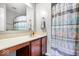 Bathroom features a vanity with a sink, a large mirror, and a shower with a decorative curtain at 1815 Kingen Dr, Greenfield, IN 46140