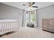 Bright bedroom features a crib, large window, and neutral decor with wood-look dresser at 1815 Kingen Dr, Greenfield, IN 46140