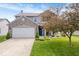 Charming two-story home featuring a well-manicured lawn, a two-car garage, and beautiful landscaping at 1815 Kingen Dr, Greenfield, IN 46140