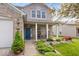 Inviting front porch featuring a seating area, landscaping, and a vibrant blue front door at 1815 Kingen Dr, Greenfield, IN 46140