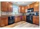 Kitchen featuring wood cabinets, modern appliances, and a window overlooking the yard at 1815 Kingen Dr, Greenfield, IN 46140