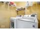 Well-equipped laundry room with white washer and dryer, and wire shelving for organized storage at 1815 Kingen Dr, Greenfield, IN 46140