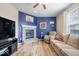 Living area with hardwood flooring, brick fireplace, and comfortable seating with vibrant blue accent wall at 1815 Kingen Dr, Greenfield, IN 46140