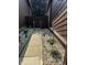 A stone walkway leads to a wooden gate between adjacent brown sided homes at 209 Brighton Ct, Greenwood, IN 46143