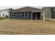 Back of home featuring vinyl siding, a small covered patio, and a large grass-covered backyard at 2159 Warbler St, Danville, IN 46122