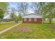 View of the backyard with a brick home, green lawn, and trees at 2321 W 26Th St, Anderson, IN 46016
