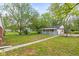 View of the backyard with a white shed and grassy lawn, surrounded by trees at 2321 W 26Th St, Anderson, IN 46016