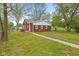 Backyard featuring a brick home, green lawn, and a concrete walkway at 2321 W 26Th St, Anderson, IN 46016