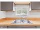 Bright kitchen features butcher block counters, gray cabinets, and a stainless steel sink beneath a window at 2321 W 26Th St, Anderson, IN 46016