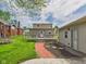 A backyard has a brick walkway, green grass, and a deck that leads to the backdoor of the house at 238 Jefferson St, Pendleton, IN 46064