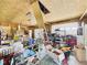 A cluttered garage with plywood walls has a ladder, storage shelves, and a white garage door at 238 Jefferson St, Pendleton, IN 46064
