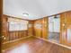 This room features wood paneled walls, hardwood floors, a window with curtains, and an open doorway at 238 Jefferson St, Pendleton, IN 46064