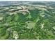 Expansive aerial view of farmland featuring lush greenery, a pond, and multiple properties at 2508 Indian Creek Rd, Trafalgar, IN 46181