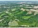 Expansive aerial view showcases a lush landscape with greenery, farms, and wooded areas at 2508 Indian Creek Rd, Trafalgar, IN 46181
