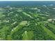 Scenic aerial view highlighting green fields, wooded areas, and scattered homes in a countryside setting at 2508 Indian Creek Rd, Trafalgar, IN 46181