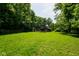 View of the spacious barn surrounded by lush green grass and mature trees on a sunny day at 2508 Indian Creek Rd, Trafalgar, IN 46181