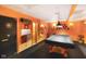 Basement game room featuring a black covered pool table, wooden walls, and storage at 2508 Indian Creek Rd, Trafalgar, IN 46181