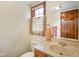 A well-lit bathroom is equipped with a toilet, vanity, sink, and window at 2508 W Indian Creek Rd, Trafalgar, IN 46181