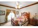 Comfortable bedroom with decorative ceiling fan, trim, and charming window treatments at 2508 W Indian Creek Rd, Trafalgar, IN 46181