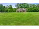 Expansive front yard featuring a charming brick home surrounded by lush greenery and mature trees at 2508 Indian Creek Rd, Trafalgar, IN 46181