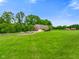 Scenic view of a charming brick home set amidst a lush green landscape and mature trees at 2508 Indian Creek Rd, Trafalgar, IN 46181