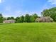 Wide shot of a home and barn on an expansive lawn under a bright blue sky at 2508 Indian Creek Rd, Trafalgar, IN 46181