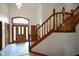 Inviting foyer with decorative chandelier, tile floors, and wood staircase with detailed banister at 2508 Indian Creek Rd, Trafalgar, IN 46181