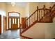 Stunning foyer featuring a grand staircase, elegant chandelier, and stylish tile flooring at 2508 Indian Creek Rd, Trafalgar, IN 46181