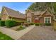 Beautiful brick home featuring a manicured lawn, mature trees, and a welcoming red front door at 2508 Indian Creek Rd, Trafalgar, IN 46181