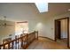 Upstairs hallway showcases a skylight and a wooden railing overlooking the foyer at 2508 Indian Creek Rd, Trafalgar, IN 46181