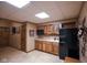 Basement kitchenette featuring tile floors, wooden cabinets, a black refrigerator, sink, and a microwave at 2508 Indian Creek Rd, Trafalgar, IN 46181
