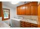 Laundry room with wooden cabinets, countertops, sink, window, washer and dryer at 2508 Indian Creek Rd, Trafalgar, IN 46181