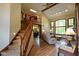 Bright living room with hardwood floors, large windows, and a view of the staircase at 2508 Indian Creek Rd, Trafalgar, IN 46181