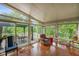 Bright sunroom featuring hardwood floors, many windows, and a glass door to the patio at 2508 Indian Creek Rd, Trafalgar, IN 46181