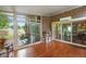Sunroom featuring red brick accent wall, hardwood floors, and glass doors leading to the yard at 2508 Indian Creek Rd, Trafalgar, IN 46181