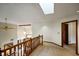Upstairs hallway with skylight, carpet, and view of the foyer and living room at 2508 Indian Creek Rd, Trafalgar, IN 46181