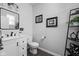 Updated half-bathroom features a modern vanity, black hardware, and decorative artwork at 2542 Barstow Dr, Whitestown, IN 46075