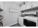 Functional laundry room offers modern machines and plenty of storage space with white cabinets at 2542 Barstow Dr, Whitestown, IN 46075