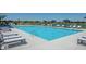 Outdoor community pool with lounge chairs and umbrellas, surrounded by a fence and green space at 2542 Barstow Dr, Whitestown, IN 46075