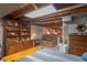 Basement space featuring exposed wooden beams, storage cabinets, and a cozy sitting area with brick accents at 295 Maple Turn Rd, Martinsville, IN 46151