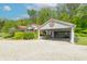 A home with a red roof, brick details, gravel driveway, a carport and well manicured landscaping at 295 Maple Turn Rd, Martinsville, IN 46151