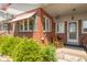 Charming covered front porch with brick accents and comfortable rocking chair seating area at 295 Maple Turn Rd, Martinsville, IN 46151