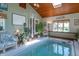 Inviting indoor pool area with comfortable seating, lush plants, and a tranquil ambiance at 295 Maple Turn Rd, Martinsville, IN 46151