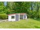 Two sheds on a lush green lawn, surrounded by a vibrant forest backdrop at 295 Maple Turn Rd, Martinsville, IN 46151