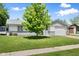 Quaint single-story home with an attached garage and a lush green lawn under a bright blue sky at 3022 Cameron St, Indianapolis, IN 46203